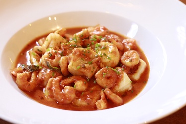 Camarões ao molho de tomate com nhoques de batata.